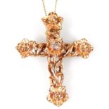 A gold crucifix pendant, on a fine link chain, the crucifx with floral design, set with tiny diamond