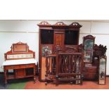 An Edwardian harlequin carved walnut bedroom suite, comprising wardrobe with shaped scroll part