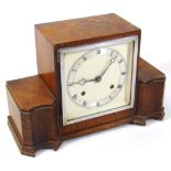 A mid 20thC oak cased mantel clock, the 14cm wide back plate raised with a Roman numeric chapter