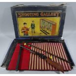 An early 20thC child's shooting gallery game, with parrots, pump action shotgun and stands,