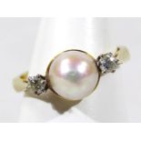 An 18ct gold cultured pearl and diamond dress ring, with central cultured pearl, flanked by two tiny