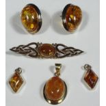 A 9ct gold amber brooch, of shaped part pierced outline, centred with a raised oval stone, 5cm wide,