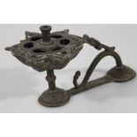 A Middle Eastern metal candlestick, with floral pierced dish holder on an entwined double domed