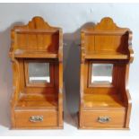 A matched pair of Edwardian satin walnut wall cabinets, of shaped outline, with central mirrors