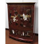 A modern Japanese finish lacquer style cabinet, the bow front with two doors profusely decorated and