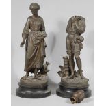 A pair of 19thC hollow cast bronze figures of a lady and gentleman, each dressed in finery, she