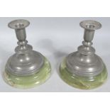 A pair of pewter dwarf candlesticks, each with bell shaped dish holders, compressed circular stems