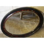 An oval mirror, with bevel glass and shaped outline, 60cm wide.