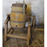 An early 20thC butter churn, the cylindrical barrel with a metal banding, the shaped top with name