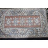 A 20thC Turkish rug, in a repeat floral and geometric pattern, predominantly in blue and cream,
