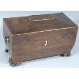 An early 19thC rosewood sarcophagus shaped tea caddy, the hinged lid revealing spaces for mixing
