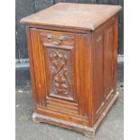 A late 19thC carved walnut coal purdonium, the overhanging square top raised above a carved panelled