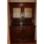 A Continental oak dresser, with cupboard top having mesh panels over two drawers and two fielded