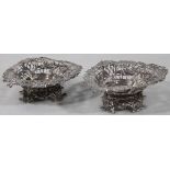 A pair of Victorian silver bon bon baskets, each with shaped pierced outlines on shaped feet, London