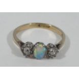 A Victorian opal and diamond dress ring, with central oval opal flanked by two tiny diamonds, yellow