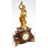 A late 19thC mantel clock, the 8cm dia. Arabic dial surmounted by a gilt metal figure entitled