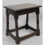 A 17thC style oak jointed stool, the rectangular overhanging top raised on baluster turned columns