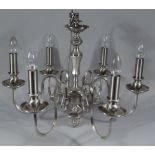 A modern metal chandelier, with six 'S' scroll stems, cylindrical candle holders and modern bulb