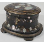 A Victorian papier maché and mother of pearl tea caddy, the oval lid heavily decorated with