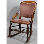 An early 20thC stained rocking chair, with upholstered back and seat in (later) pink material, on