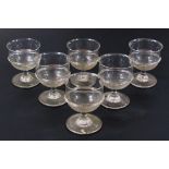 A set of six early 19thC drinking glasses, each with shaped bowls, compressed stems and circular
