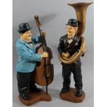 Two modern resin figures of Laurel and Hardy, playing musical instruments, 49cm high. (2)