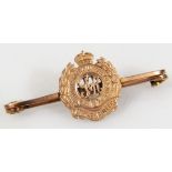 A Royal Engineers pin badge, with plain elaborate garland centre, marked 9ct, 5cm wide, 3g.