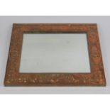 An Arts & Crafts copper framed rectangular wall mirror, embossed with flowers and entwined leaves,