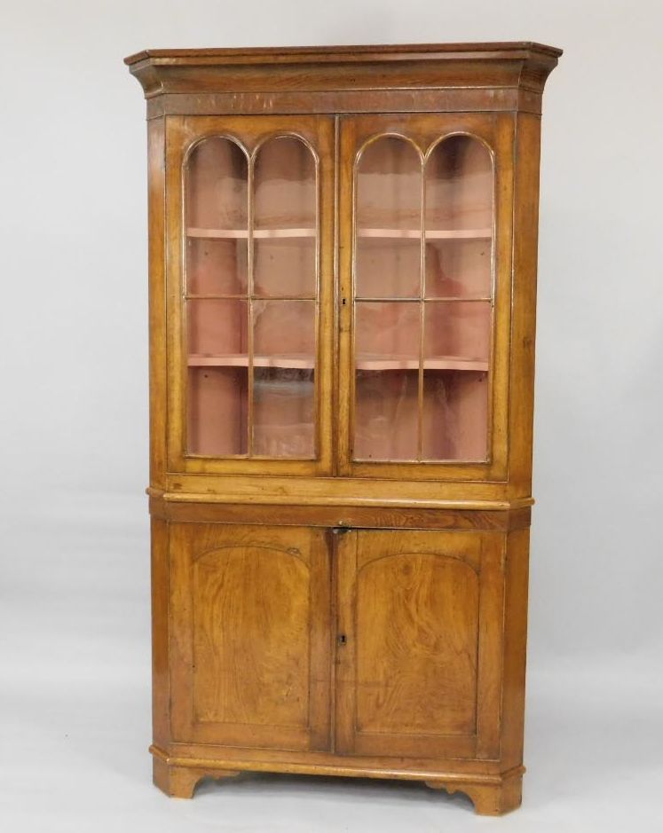 A George oak standing corner cabinet, with glazed upper section, enclosed by two doors with plain