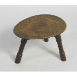 A 19thC rustic oak and fruitwood stool, with a saddle shaped seat and tapering back legs, 60cm