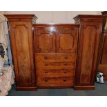 A Victorian figured mahogany wardrobe, the central section with two panelled doors above two short