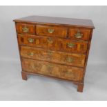 A George II walnut and cross banded chest of drawers, with one medium and two short drawers, over