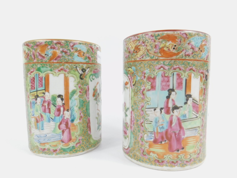 A pair of 19thC Cantonese vases, each squat cylindrical body decorated with panels of figures,