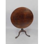 A George III mahogany tilt top occasional oval table, raised on a turned and spiral fluted column,