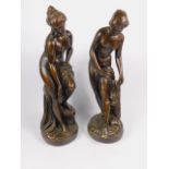 A pair of late 19thC bronzed plaster figures modelled on Venus bathing, raised on circular bases,