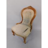 A Victorian walnut spoon back nursing chair, with overstuffed seat and button back, raised on
