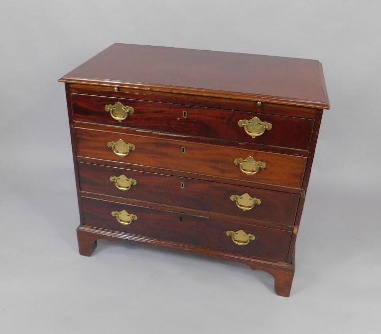 A George III mahogany bachelor's chest of drawers, with brushing slide over four long drawers,