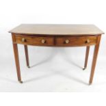 A George III mahogany bow fronted side table, the top with a reeded edge, above two frieze