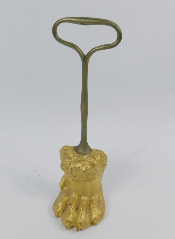 A 19thC gilt cast iron door porter, in the form of a lions paw with a brass handle
