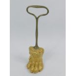 A 19thC gilt cast iron door porter, in the form of a lions paw with a brass handle