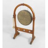 A Victorian oak Gothic style dinner gong, the stand with an arched top and with pierced stretcher