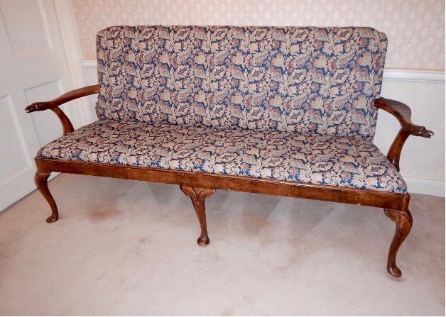 A rare early 18thC walnut framed settee, with carved bird's head terminals to the arms, and later