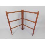 An Edwardian mahogany folding towel rail, on shaped legs, 105cm wide