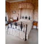A Victorian half tester cast iron framed bed, with fitted drapes.