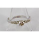 A diamond solitaire ring, set in white metal stamped 18ct, with diamond set shoulders, approx 0.
