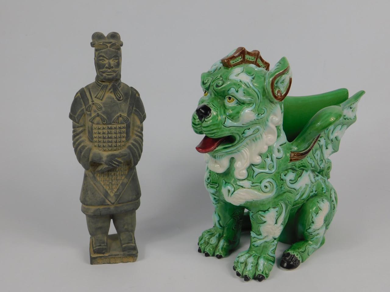 A Chinese Porcelain figural vase modelled as a winged lion, moulded with dragons chasing flaming