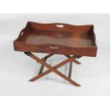 A mahogany butler's tray on stand, of rectangular form with four pierced handles on folding stand,