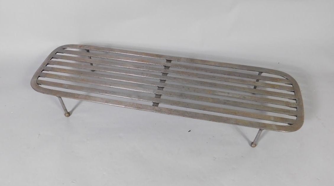 A large 19thC steel trivet, with slatted top and ball feet and poker, 108cm wide