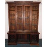 An early 19thC mahogany breakfront bookcase, with blind fret carved frieze above four doors, each