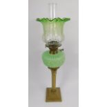 A late 19thC brass Corinthian column oil lamp, with an acanthus moulded green moulded glass